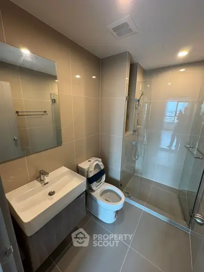 Modern bathroom with sleek design, glass shower, and elegant fixtures in a contemporary apartment.