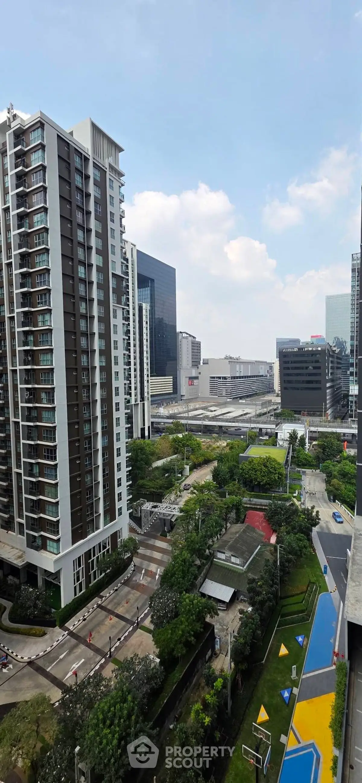 Stunning urban view of modern high-rise buildings and lush greenery in a vibrant cityscape.