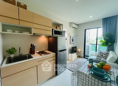 Modern kitchen and living area with sleek appliances and natural light