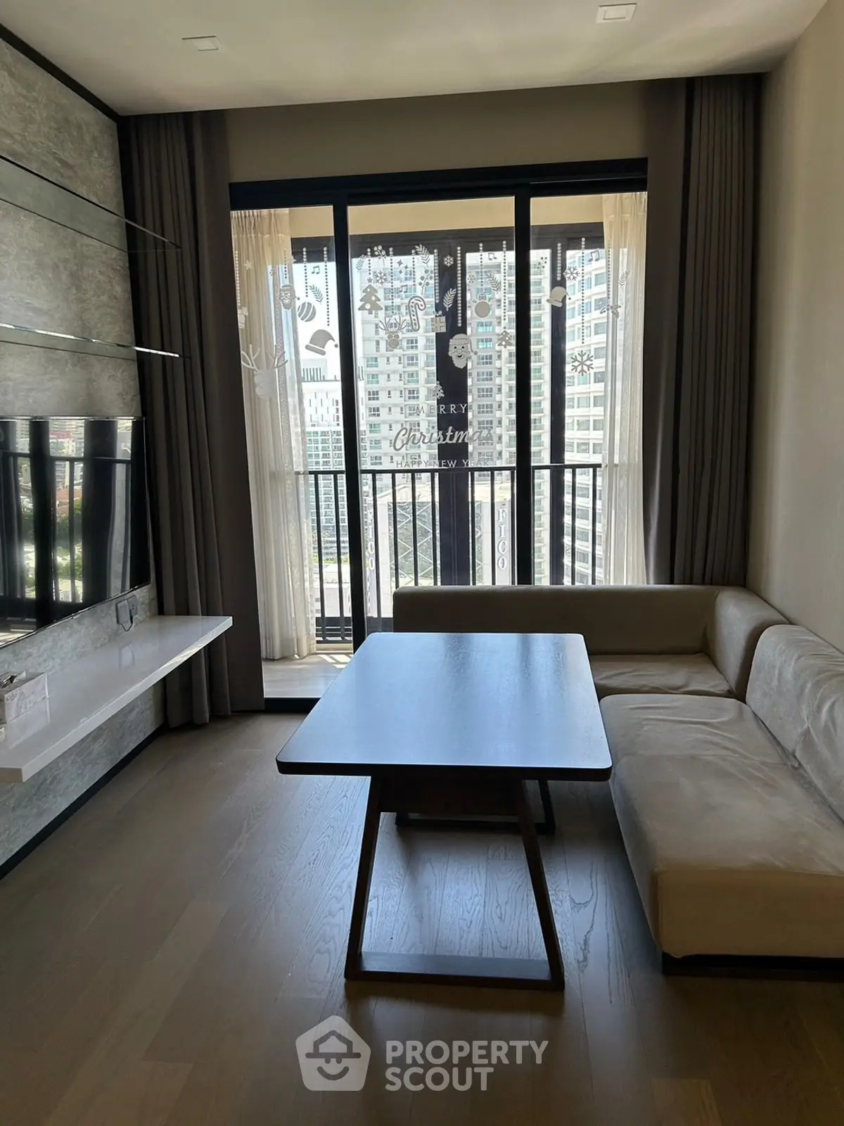 Modern living room with large window and city view, featuring sleek furniture and elegant decor.