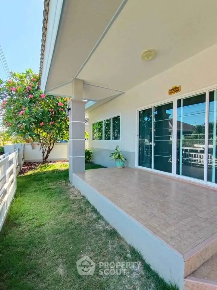 Charming home exterior with lush garden and spacious patio, perfect for relaxation and outdoor enjoyment.