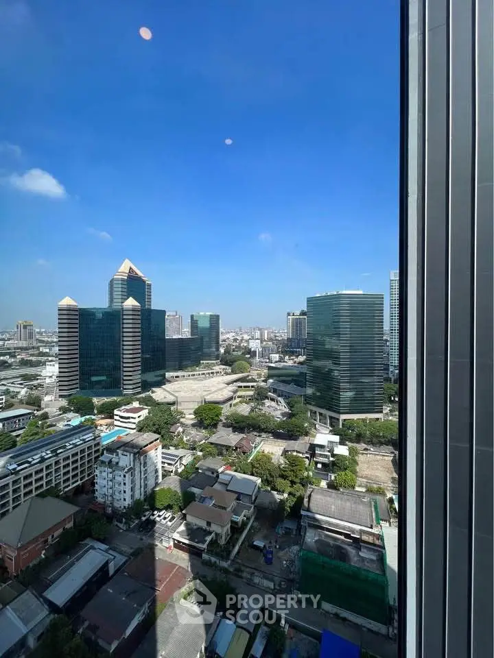 Stunning cityscape view from high-rise building with clear blue sky.