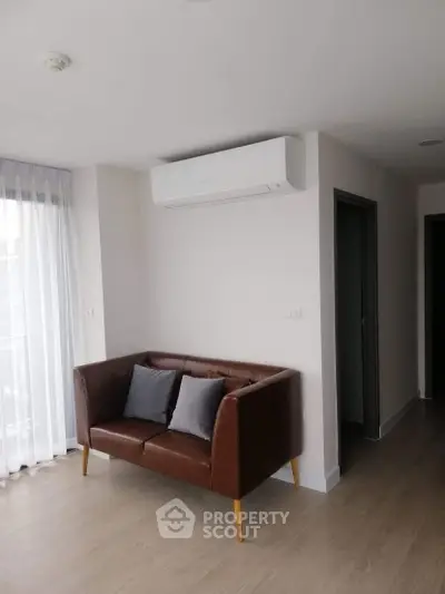 Modern living room with sleek leather sofa and air conditioning unit