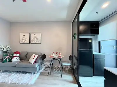 Modern living room with cozy decor and adjacent compact kitchen