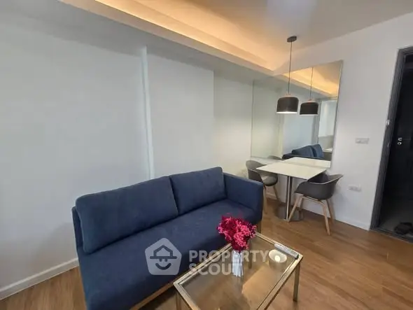 Modern living room with blue sofa and stylish dining area