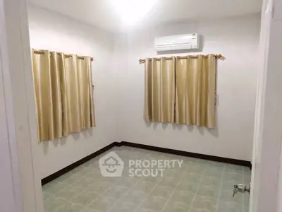 Spacious empty room with tiled floor and air conditioning, ready for customization.