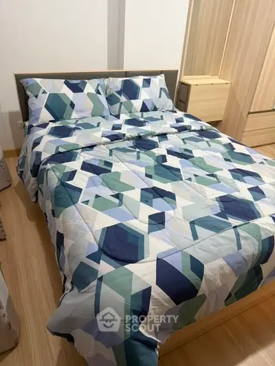 Cozy bedroom with geometric patterned bedding and wooden wardrobe