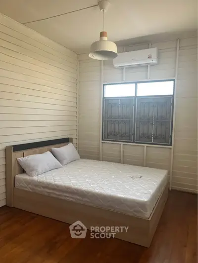 Cozy bedroom with wooden flooring and modern lighting in a serene home setting.