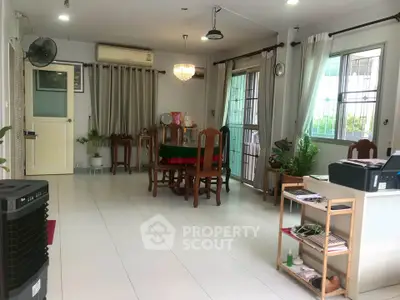 Spacious living room with elegant dining set and natural light, perfect for family gatherings.