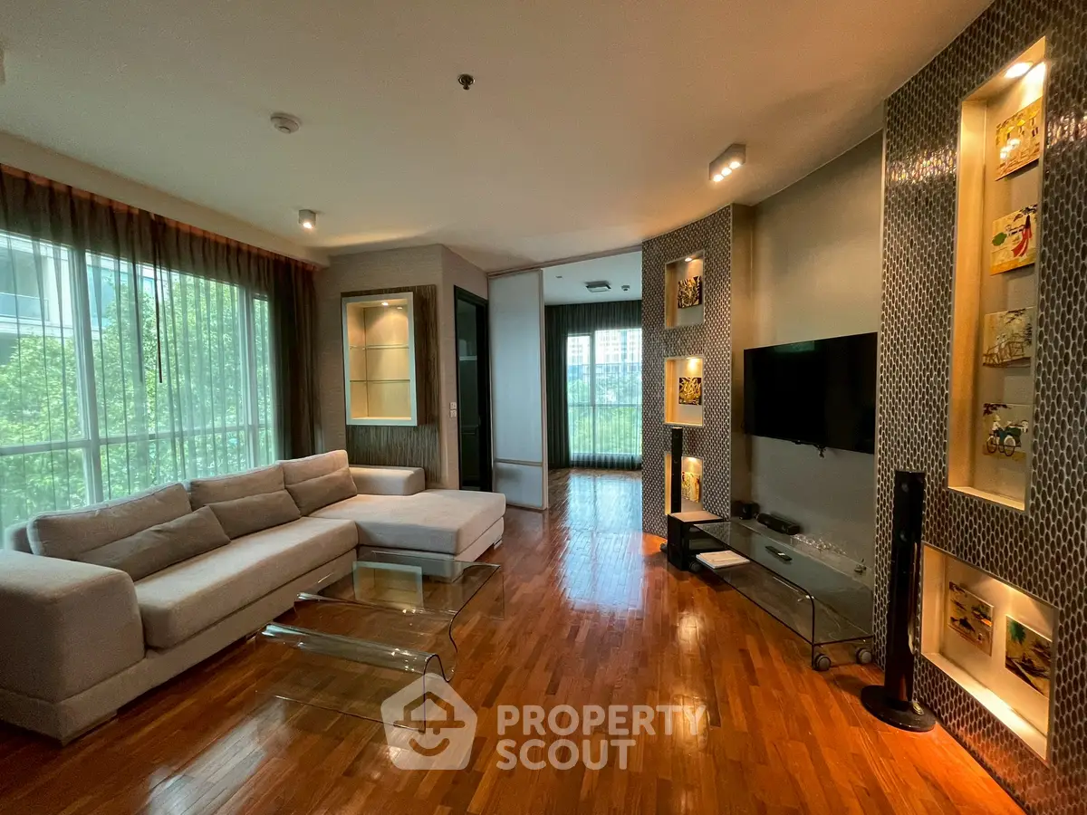 Spacious modern living room with elegant decor and large windows offering natural light and scenic views.