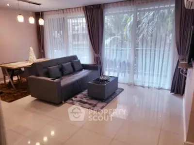 Modern living room with elegant decor and large windows offering natural light and a serene view.