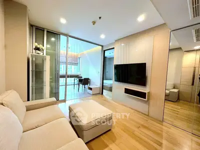 Modern living room with sleek design and open layout, featuring a cozy sofa and wall-mounted TV.