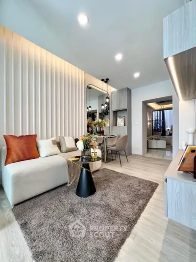 Modern living room with stylish decor and open layout, featuring cozy seating and elegant lighting.