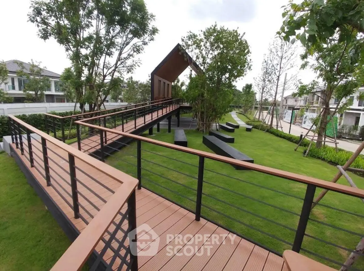Modern garden with wooden walkways and lush greenery in a residential area.