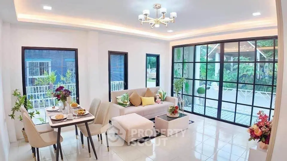 Spacious modern living room with large windows and elegant dining area