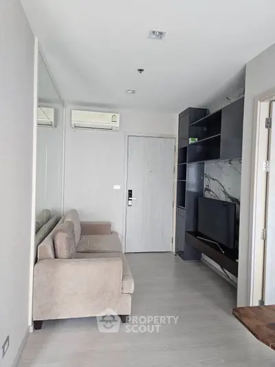 Modern living room with sleek design, featuring a comfortable sofa and wall-mounted TV unit.