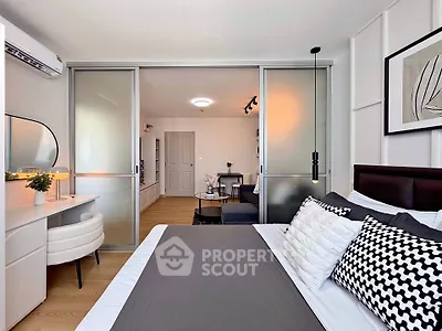 Modern bedroom with stylish decor and sliding glass doors leading to a cozy living area.