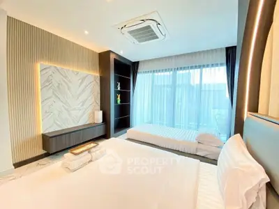 Luxurious bedroom with modern decor and large windows offering natural light