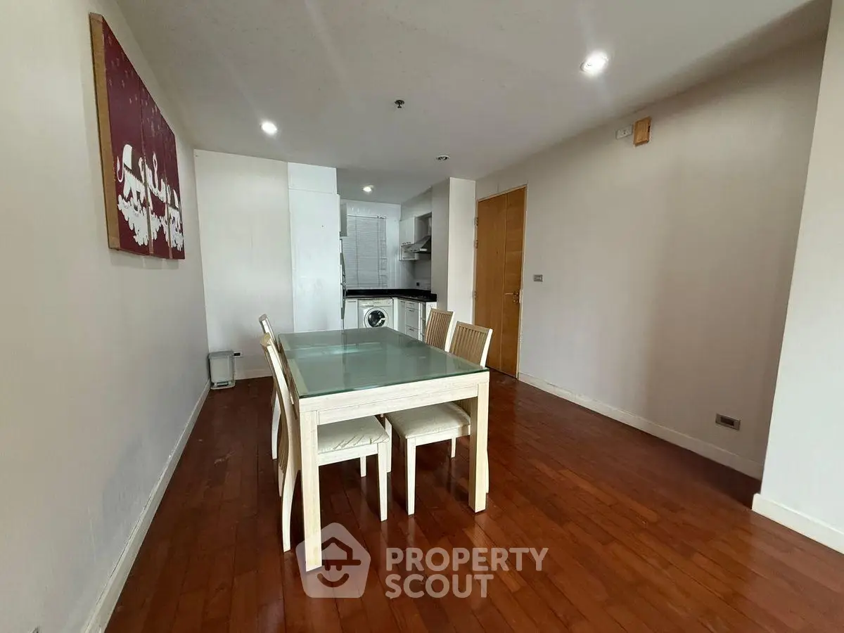 Spacious dining area with wooden flooring and modern kitchen view