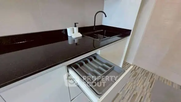 Modern kitchen with sleek black countertop and open drawer