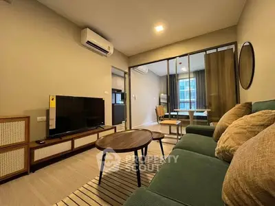 Modern living room with stylish furniture and open view to dining area