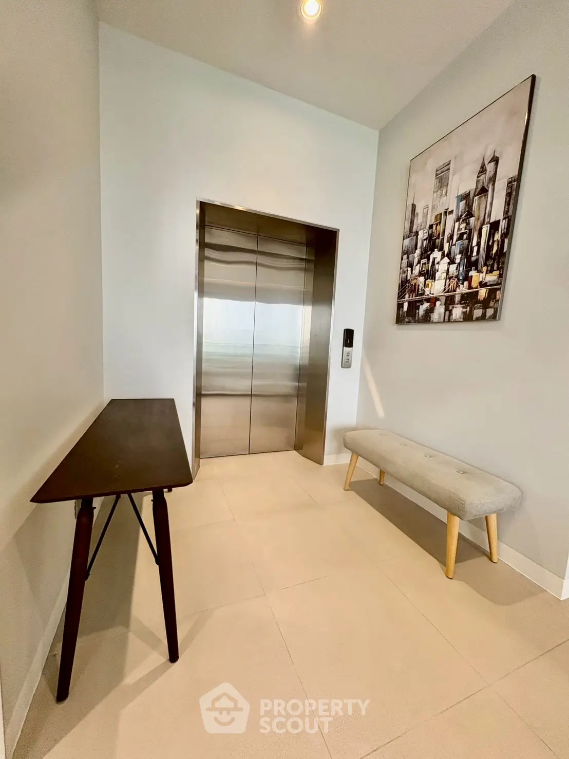 Modern elevator lobby with stylish decor and cityscape artwork.