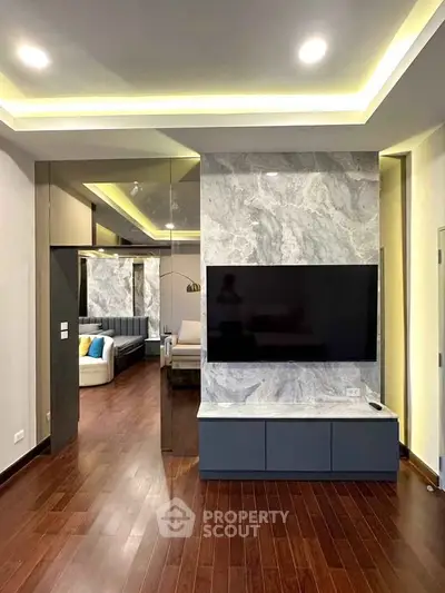 Modern living room with sleek TV setup and elegant marble wall design