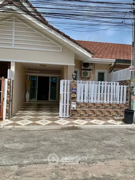 Charming single-story home with tiled entrance and white picket fence