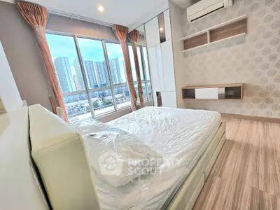 Modern bedroom with large windows offering stunning city views in a high-rise apartment.