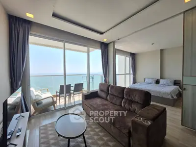 Luxurious open-plan living room with stunning ocean view and spacious balcony.