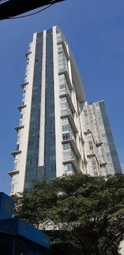 Modern high-rise building with sleek design and large windows in urban setting.