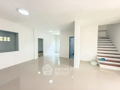 Spacious modern living room with sleek tile flooring and staircase