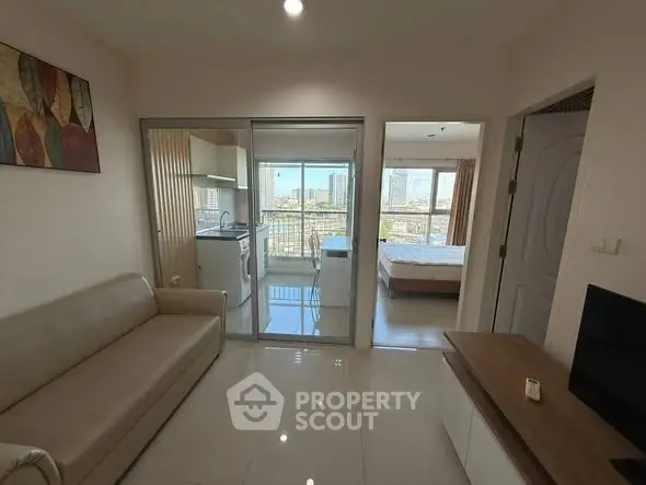 Modern apartment with open living room and kitchen, city view from balcony.