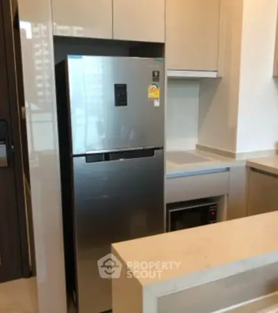 Modern kitchen with sleek appliances and stylish cabinetry in a contemporary apartment.