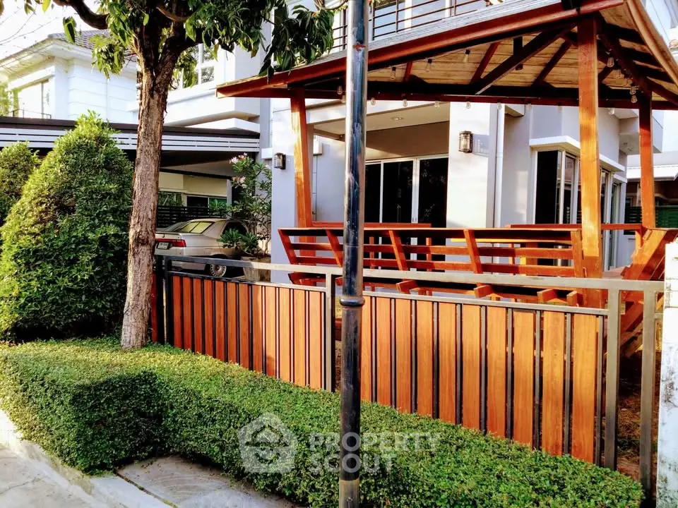 Charming modern home with wooden accents and lush greenery in a serene neighborhood.