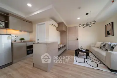 Modern living room with open kitchen, stylish decor, and natural light in a contemporary apartment.