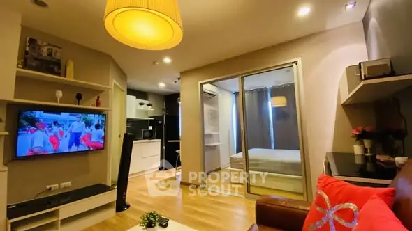 Modern open-plan living room with cozy decor and sliding glass doors to bedroom