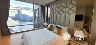 Luxurious bedroom with stunning river view and elegant decor in high-rise apartment.