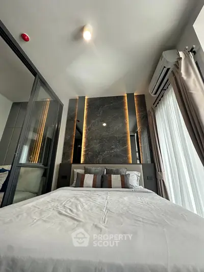 Modern bedroom with stylish lighting and large window