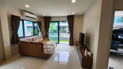 Spacious living room with modern decor and large windows offering garden views.