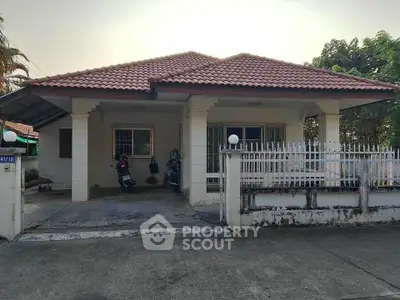 Charming single-story home with tiled roof and spacious driveway in a serene neighborhood.