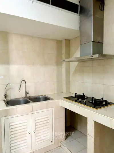 Modern kitchen with dual sink and gas stove in a compact layout