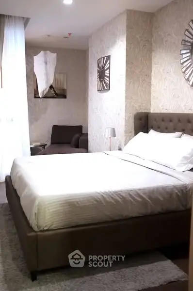 Luxurious bedroom with elegant decor and plush bedding in modern apartment.