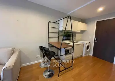 Modern compact kitchen with washing machine and breakfast bar in cozy apartment.
