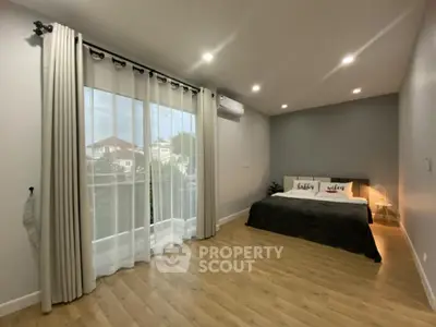 Spacious modern bedroom with large window and elegant decor