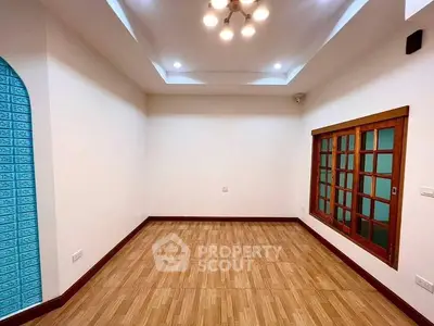 Spacious empty room with wooden flooring and modern lighting, ideal for customization.