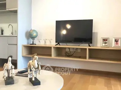 Modern living room with mounted TV and stylish decor in a cozy apartment.