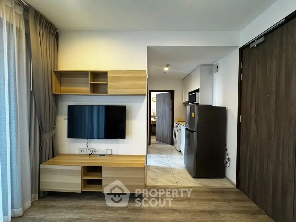 Modern living room with sleek wooden furniture and open kitchen layout