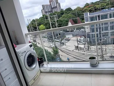 Modern balcony with washing machine and city view, perfect for urban living.