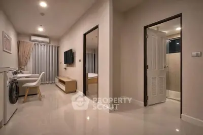 Modern apartment interior with sleek living area and washing machine, showcasing contemporary design and functionality.